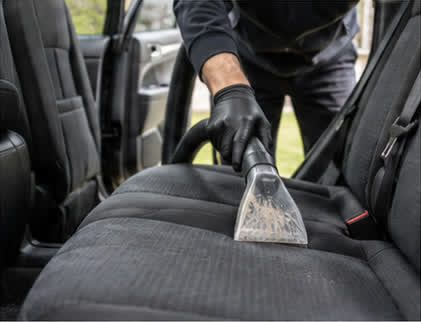 Extraction tool lifting dirt from a cloth car seat